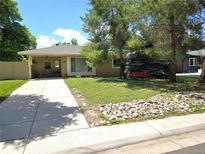 Charming single-story home featuring a well-maintained lawn, mature trees, and a welcoming front porch with seating at 1245 S Forest St, Denver, CO 80246