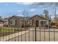 Charming home showcasing a walkway to the front door, a small lawn, and wrought iron fencing at 235 N 7Th Ave, Brighton, CO 80601