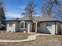 Charming single-story home featuring a well-maintained lawn, attractive landscaping and a brick exterior with stone accents at 3001 Fairfax St, Denver, CO 80207