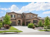 Beautiful two-story home featuring a well-manicured lawn and a spacious driveway leading to two garages at 2130 S Poppy St, Lakewood, CO 80228