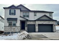 Two-story house with gray siding, stone accents, and a two-car garage at 3340 Backdrop Ct, Castle Rock, CO 80108