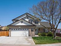 Charming two-story home with a brick facade, a well-manicured lawn, and a spacious two car garage at 13972 Hudson Way, Thornton, CO 80602