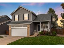 Charming two-story home with gray siding, attached garage, and manicured lawn at 18997 E Crestridge Cir, Aurora, CO 80015