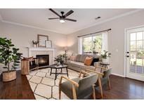 Cozy living room with a fireplace, modern ceiling fan, and comfortable seating on a patterned rug at 18997 E Crestridge Cir, Aurora, CO 80015