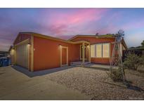 Charming single Gathering home featuring a gravel front yard and a windmill decoration at 253 Cherokee Pl, Brighton, CO 80603