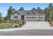 Charming home with a three-car garage, stone accents, and well-maintained landscaping at 1798 Summerglow Ln, Monument, CO 80132
