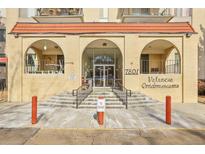 Valencia Condominiums brick entrance with arched entryways, stairs and railings plus signage and address at 7801 W 35Th Ave # 409, Wheat Ridge, CO 80033