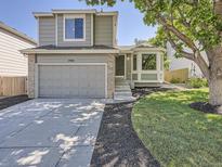 Charming two-story home featuring a well-maintained lawn, gray siding, and an attached two-car garage at 17014 Carr Ave, Parker, CO 80134