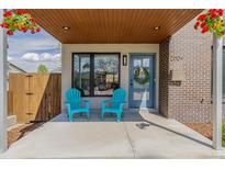 Inviting front porch featuring two blue Adirondack chairs and colorful hanging flower baskets adding curb appeal at 2004 S Galapago St, Denver, CO 80223