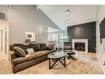 Comfortable living room featuring a fireplace with decorative marble and modern pendant lighting at 8100 W Quincy Ave # 11, Denver, CO 80123
