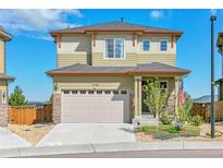 Two-story house with light beige siding, two-car garage, and landscaping at 3338 Youngheart Way, Castle Rock, CO 80109