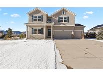 Two-story house with a large driveway and snow-covered lawn at 17630 Water Flume Way, Monument, CO 80132