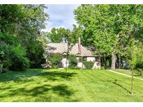 Charming single story home featuring a lush green lawn and mature trees at 1930 Hoyt St, Lakewood, CO 80215