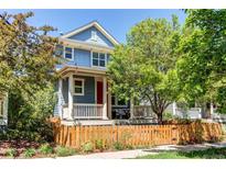 Charming two-story home with a red door, front porch, and a picket fence at 3353 Wabash St, Denver, CO 80238
