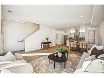 Open-concept living room featuring sleek furnishings, hardwood floors, and a staircase at 1416 Pierce St, Lakewood, CO 80214
