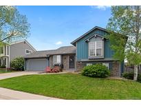 Charming exterior with blue siding, stone accents, and a well-manicured lawn and features two red Adirondack chairs at 21524 E Powers Pl, Centennial, CO 80015
