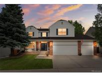 Charming two-story home featuring a well-manicured lawn, a two-car garage, and a welcoming front porch with porch swings at 2795 Signal Creek Dr, Thornton, CO 80241