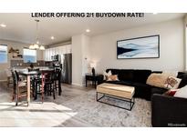 Inviting open-concept living room featuring modern decor and an adjacent kitchen with stainless steel appliances at 1312 Independence St # 3, Lakewood, CO 80215