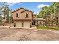 Inviting two-story home featuring a two-car garage, stone accents, and a well-manicured front yard at 17540 Caribou Dr, Monument, CO 80132