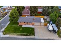 Aerial view of brick home featuring a well-maintained lawn and a long driveway for parking at 5320 W 62Nd Ave, Arvada, CO 80003