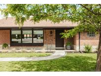 Charming brick home featuring a professionally landscaped yard and inviting front entrance at 2060 Kline St, Lakewood, CO 80215