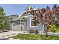 A cozy home exterior showing the garage, lawn, and well-placed landscaping at 12993 E 108Th Ave, Commerce City, CO 80022