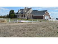 Charming two-story home with a white fence and well-maintained lawn at 74500 E 136Th Ave, Byers, CO 80103