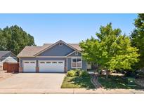 Charming single-Gathering home features a three-car garage, lush lawn and mature shade trees at 1884 Asoka St, Strasburg, CO 80136