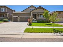 Charming two-story home featuring a three car garage, front porch, and well-maintained landscaping at 17056 E 111Th Ave, Commerce City, CO 80022