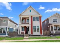 Charming red and white two-story home featuring a welcoming front porch and manicured lawn at 213 Washington St, Erie, CO 80516