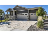 Beautiful home featuring a three car garage and a well-maintained concrete driveway on a sunny day at 15919 Xanthia Way, Thornton, CO 80602