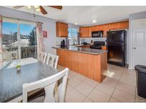 Bright kitchen with wood cabinets, breakfast bar, and adjacent dining area with water view at 18971 E Mercer Dr, Aurora, CO 80013