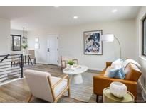 Bright living room with hardwood floors, neutral paint, and a leather sofa, creating an inviting space at 10792 Moore St, Broomfield, CO 80021
