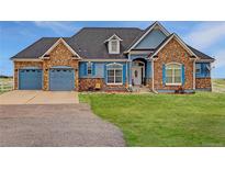 Charming home with stone accents, blue siding, and a well-manicured lawn on a sunny day at 38025 E 145Th Pl, Keenesburg, CO 80643