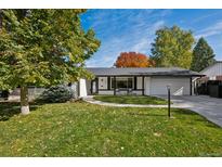 Charming single-story home with a well-manicured lawn, mature trees, and a two-car garage at 2602 S Kearney St, Denver, CO 80222