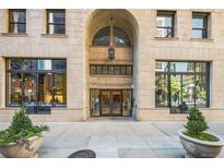Elegant Midland Lofts entrance featuring an arched doorway, glass doors, and decorative planters adding charm to the façade at 444 17Th St # 807, Denver, CO 80202