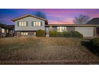 Charming two-story home boasts green shutters, brick accents, and mature landscaping in a tranquil neighborhood at 10636 Ura Ln, Northglenn, CO 80234