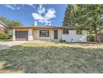 Charming single story home featuring a well-kept lawn, a covered porch, and attached garage at 8463 W Arizona Dr, Lakewood, CO 80232