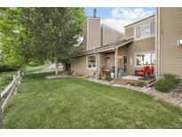 Charming home exterior with a well-maintained lawn, deck, and neutral siding at 6948 Buckskin Dr, Littleton, CO 80125