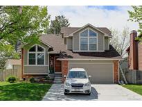 Charming two-story home boasts a well-maintained yard, a driveway with a white car, and beautiful architectural features at 8555 Angela Ln, Parker, CO 80134