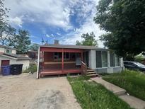 Cozy single-Gathering home featuring a covered porch, driveway, and mature trees at 882-888 Wolff St, Denver, CO 80204