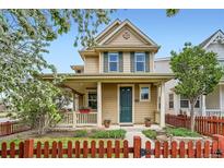 Charming two-story home with front porch and vibrant red picket fence enhancing curb appeal at 2538 Central Park Blvd, Denver, CO 80238