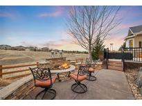 Outdoor firepit with circular seating in a backyard with chairs and scenic views at 5118 Bottlebrush Run, Broomfield, CO 80023