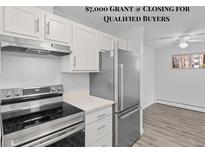 Updated kitchen with stainless steel appliances, white cabinets, and modern countertop at 6455 E Bates Ave # 3-102, Denver, CO 80222