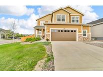 Inviting two-story home with a well-manicured lawn, a large garage, and beautiful stone accents at 3762 White Rose Loop, Castle Rock, CO 80108
