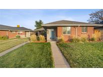 Brick ranch home with a landscaped yard and a blue front door at 3608 N Grape St, Denver, CO 80207