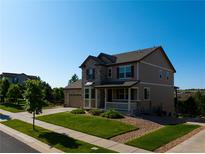 Charming two-story home boasts a stone facade, covered front porch, and well-manicured lawn at 22268 E Hidden Trail Dr, Parker, CO 80138