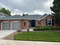 Charming single-story red brick home with a well-manicured lawn and attached two-car garage at 8717 Forrest Dr, Highlands Ranch, CO 80126