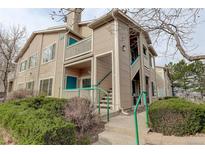 Exterior view of the two-story condo building with private balconies and well-maintained landscaping at 8415 Pebble Creek Way # 102, Highlands Ranch, CO 80126