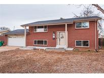 Charming two-story red brick home with a well-maintained lawn and inviting front entrance at 889 Douglas Dr, Denver, CO 80221